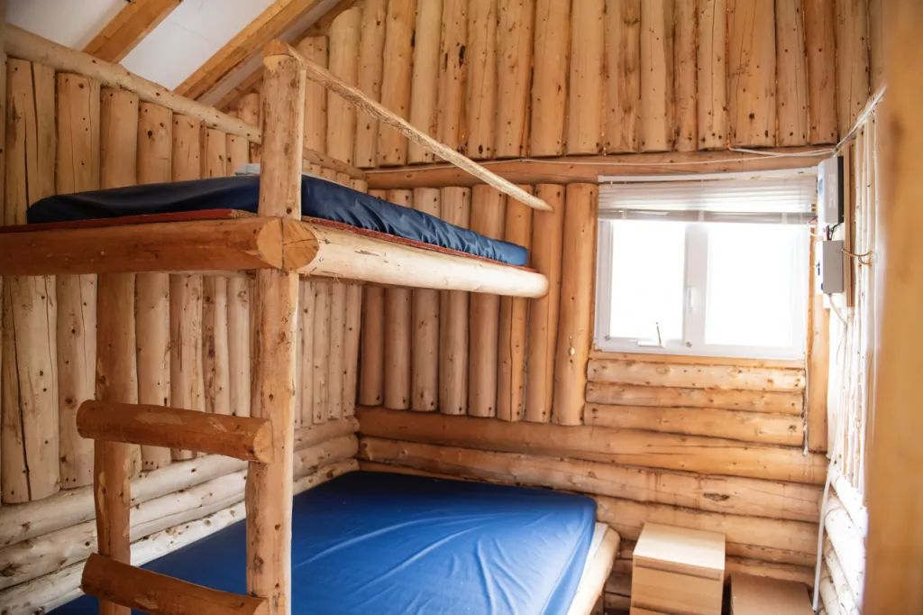 Le chalet dispose d'un lit superposé en bois rond avec matelas dans la chambre.