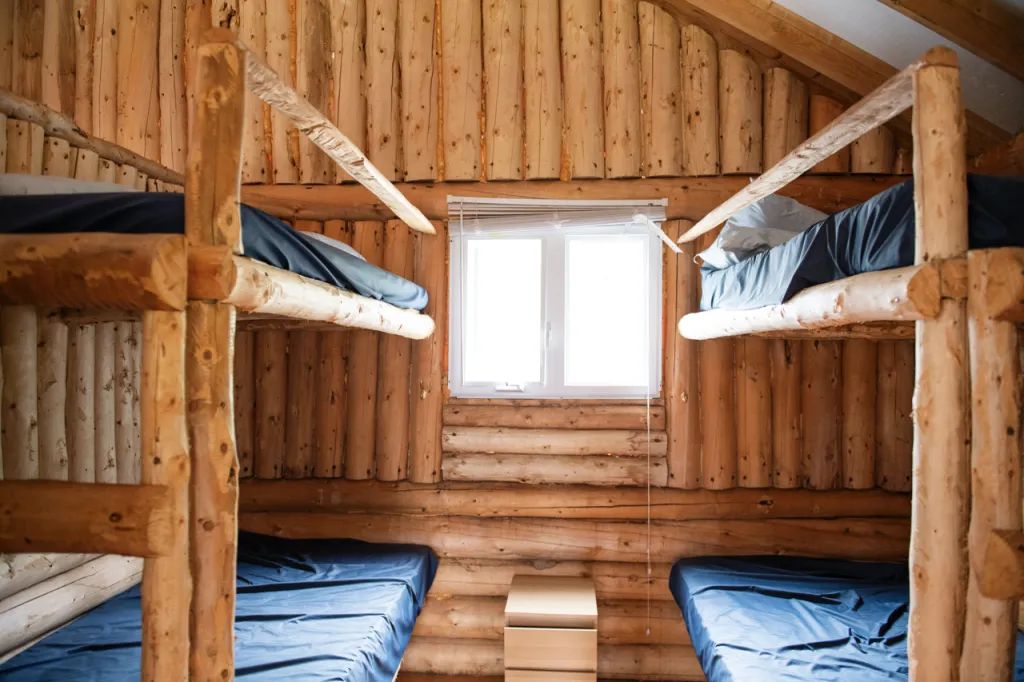 Cette chambre rustique est équipée de lits superposés en bois rond.