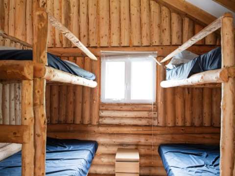 Cette chambre rustique est équipée de lits superposés en bois rond.