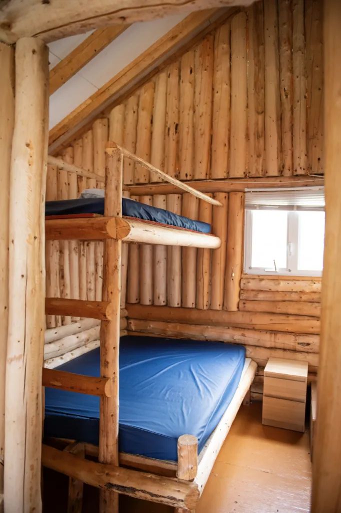 Cette chambre rustique du chalet 6 dispose de lits superposés en bois rond.
