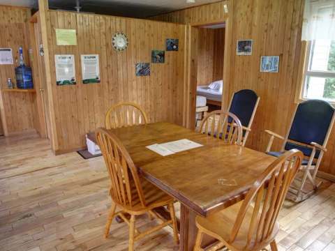 La salle à manger du chalet De la Croix offre un espace chaleureux avec ses murs en lambris de bois.