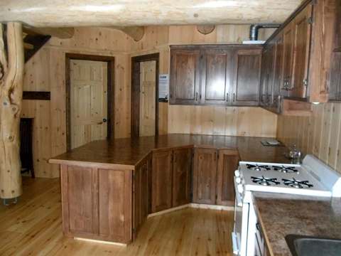 La cuisine équipée du chalet avec ses armoires en bois et son comptoir fonctionnel.