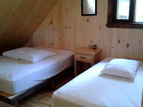 Vue sur la chambre mansardée équipée de deux lits dans le chalet Le Pygargue.