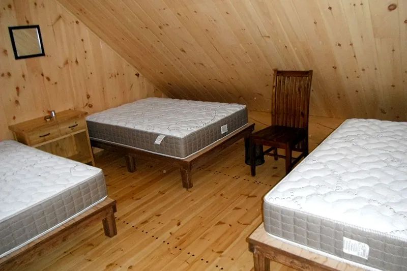 La mezzanine du chalet Le Pygargue est aménagée avec trois lits simples.