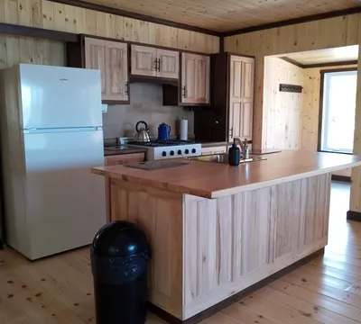 The fully equipped kitchen of Le Touladi cottage features a central island and appliances.