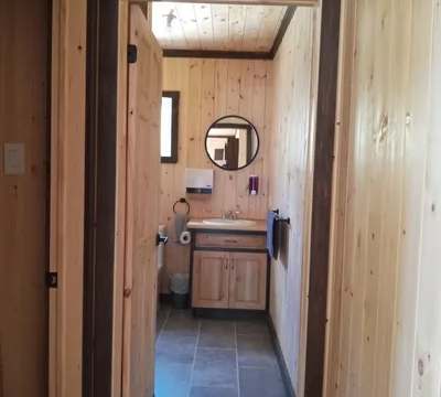 View of the Le Touladi cottage bathroom featuring natural wood walls.