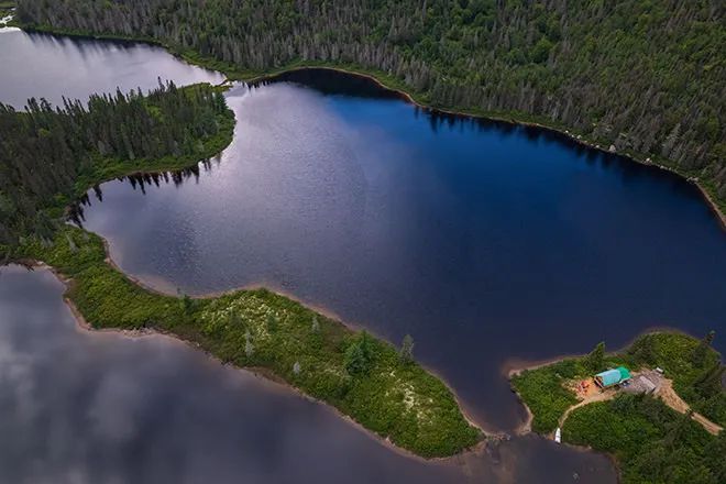 Vue aérienne du chalet numéro un situé sur une presqu'île en bordure du lac.