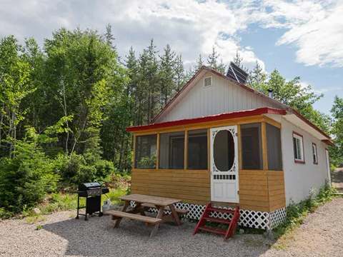 Le chalet numéro 2 dispose d'une véranda grillagée et d'une table de pique-nique extérieure.