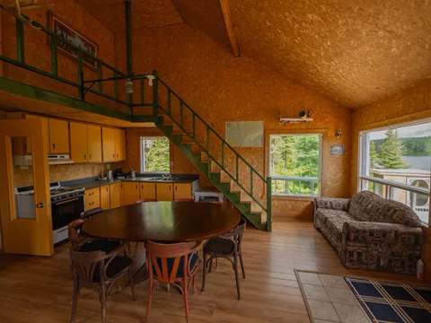 Espace de vie chaleureux comprenant une cuisine fonctionnelle, un coin repas et un salon.