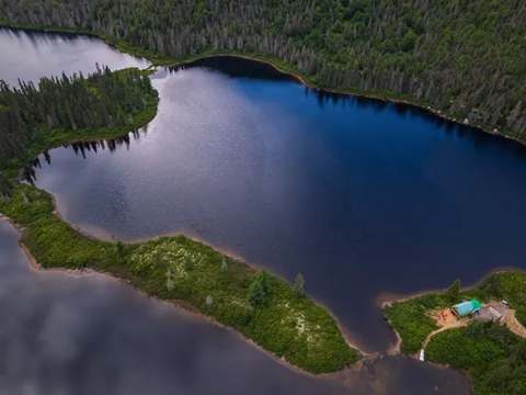 Vue aérienne du chalet numéro un situé sur une presqu'île en bordure du lac.