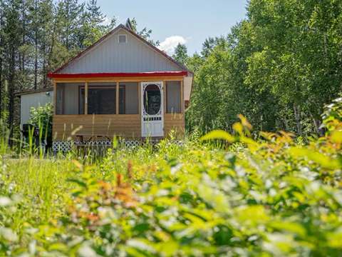 Le chalet numéro 2 est situé dans un environnement boisé et entouré de verdure.