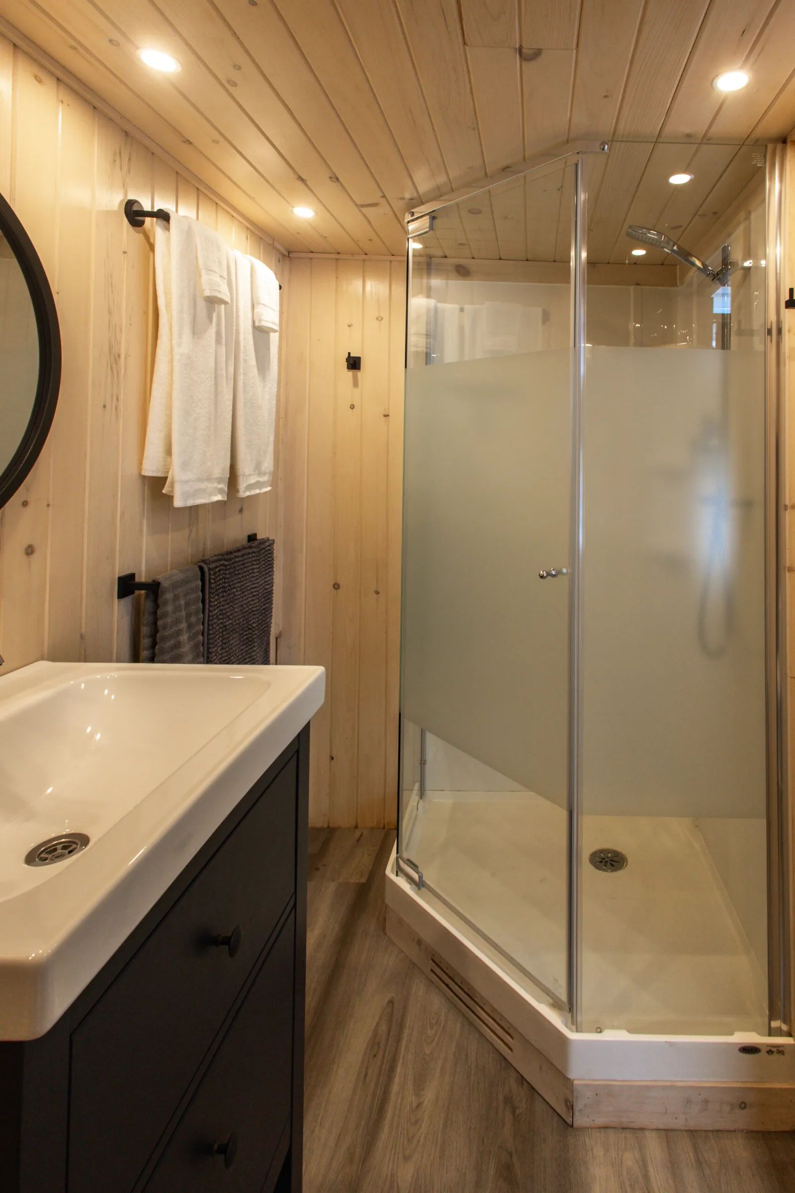 The modern bathroom features a corner shower and a functional vanity.