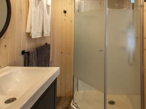 The modern bathroom features a corner shower and a functional vanity.