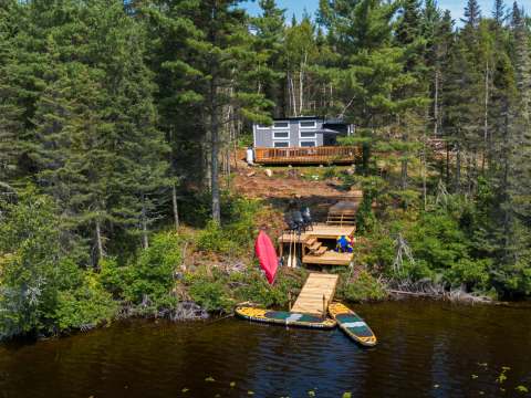 Aerial view of chalet 10, its deck, and its private lake access with a dock.