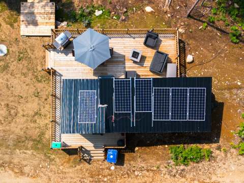 Aerial view of the chalet's furnished deck and solar panel-equipped roof.