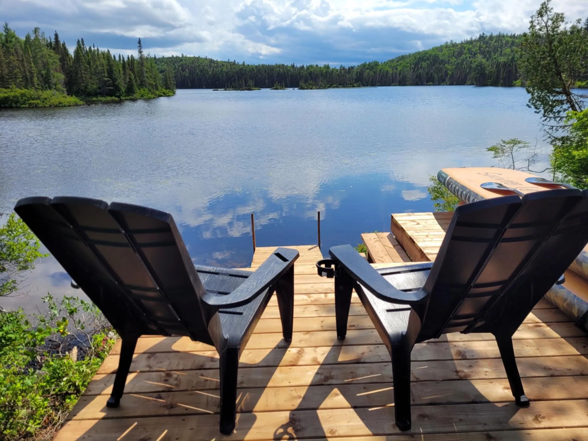 Two comfortable chairs on the private dock offer a stunning view of the lake.