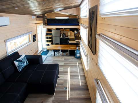 Overview of the tiny house interior with a living area, kitchen, and mezzanine.