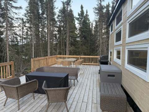 The large deck of cabin 8 is furnished with patio furniture and a barbecue.