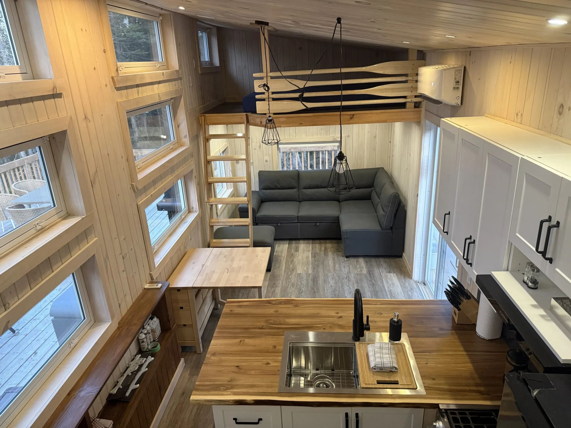 High-angle view of the cabin's living area including the kitchen, living room, and mezzanine.