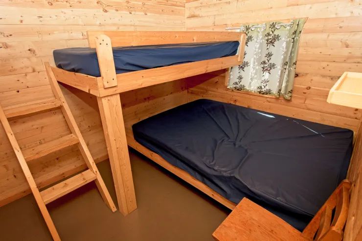 Cette chambre de chalet comprend un lit superposé avec des matelas aux finitions robustes.