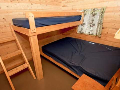 Cette chambre de chalet comprend un lit superposé avec des matelas aux finitions robustes.