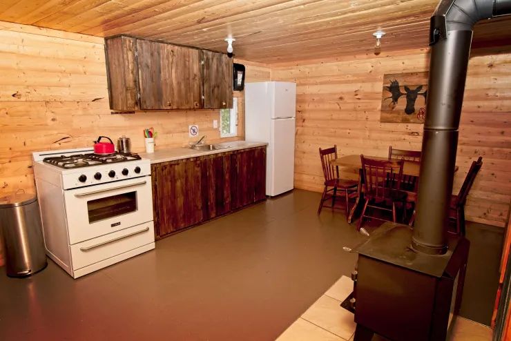La cuisine équipée et l'espace repas du chalet 1 en bois rond.