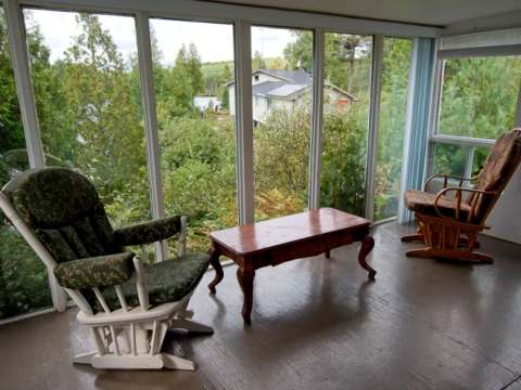Profitez de la vue sur le lac et la forêt depuis la véranda vitrée du chalet.