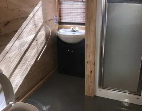 La salle de bain du chalet comprend une douche, un lavabo et une toilette.
