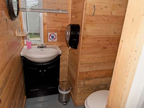 Vue de la salle de bain fonctionnelle avec lavabo et toilette dans le chalet.