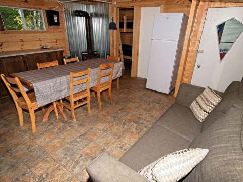 L'intérieur du chalet comprend une aire ouverte avec salle à manger, coin salon et cuisine.