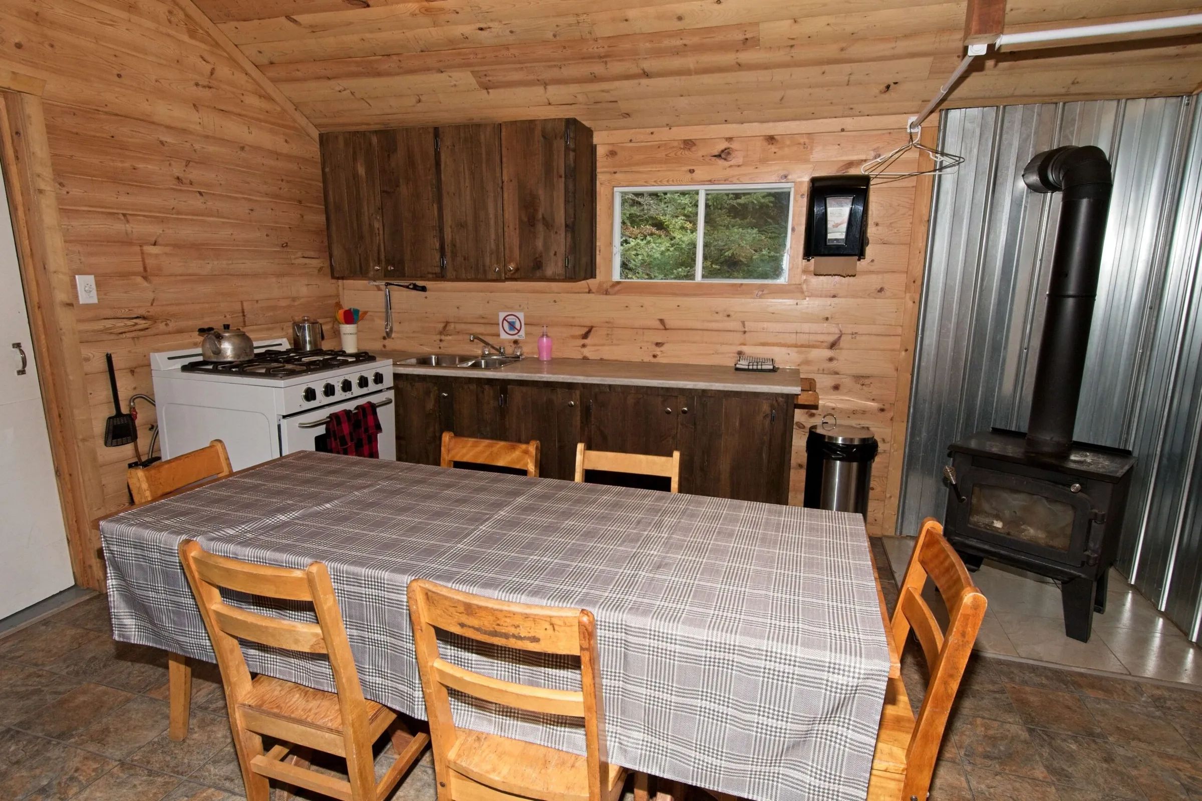 La cuisine équipée du chalet dispose d'une table à manger et d'un poêle à bois.