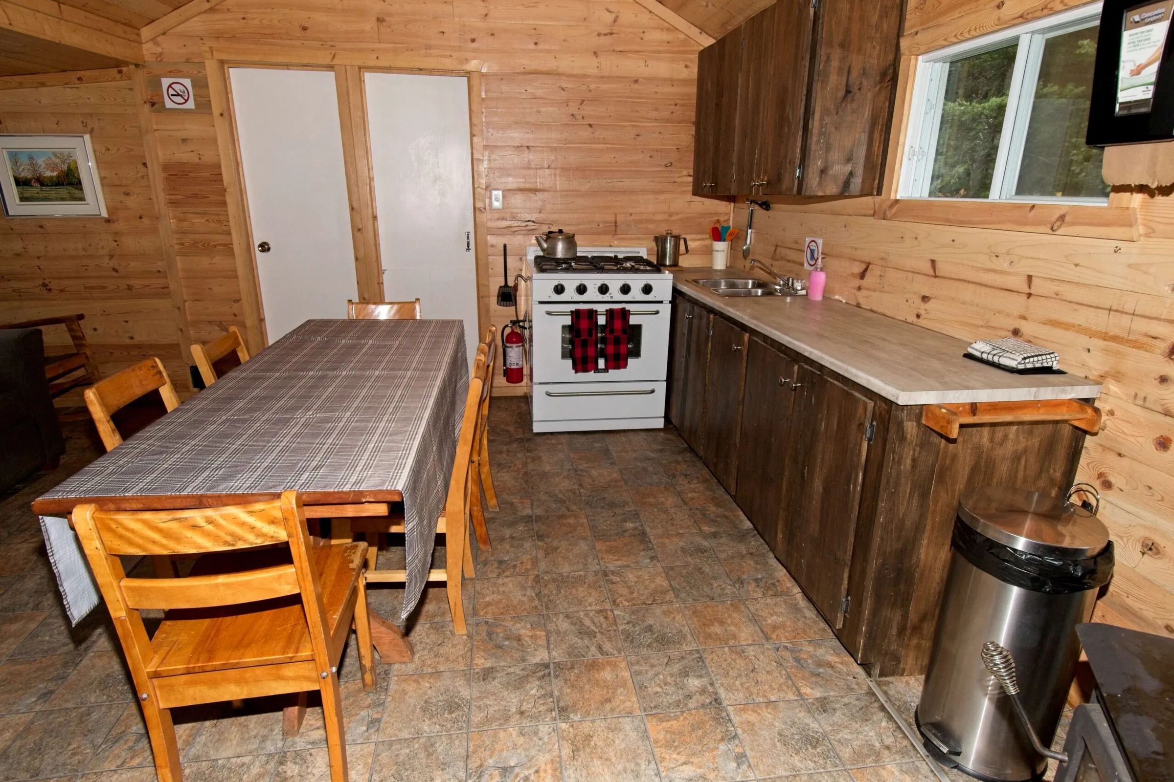 La cuisine équipée et l'espace repas du chalet 4 disposent d'une cuisinière et d'une table en bois.