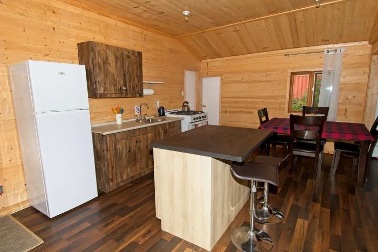 La cuisine équipée du chalet 3 comprend un îlot central et une table à manger.