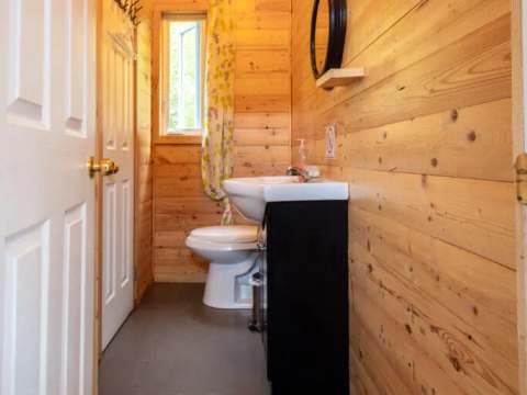 Vue de la salle de bain du chalet, équipée d'un lavabo et d'une toilette.