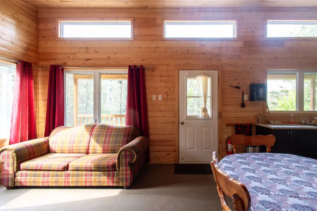 L'aire ouverte du chalet comprend un coin salon avec divan et une salle à manger adjacente.