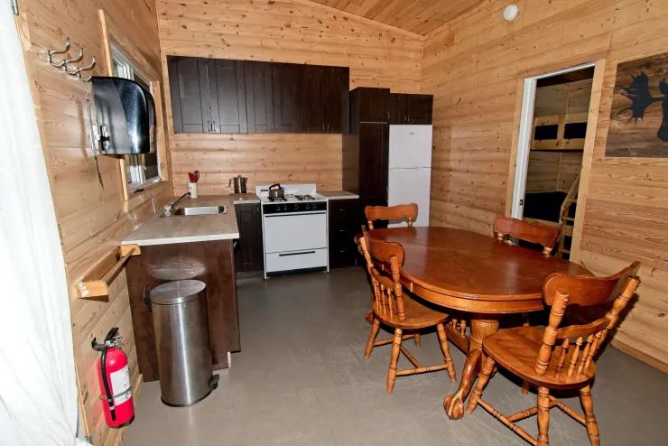 La cuisine équipée et la salle à manger du chalet 7 offrent un espace convivial tout en bois.