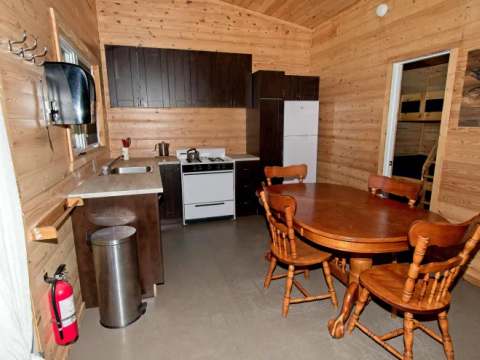 La cuisine équipée et la salle à manger du chalet 7 offrent un espace convivial tout en bois.