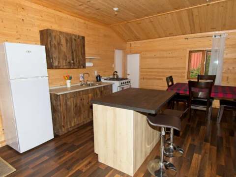 La cuisine équipée du chalet 3 comprend un îlot central et une table à manger.