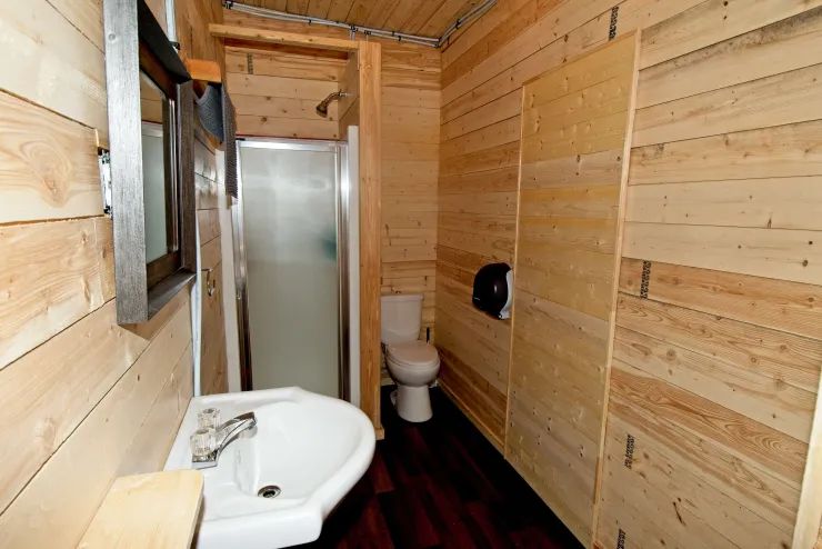 Cette salle de bain fonctionnelle est aménagée avec des murs en lambris de bois naturel.