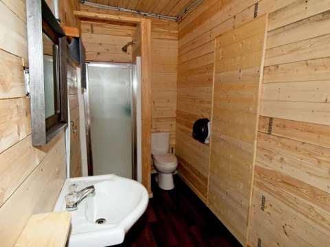 Cette salle de bain fonctionnelle est aménagée avec des murs en lambris de bois naturel.