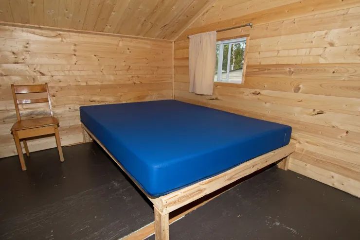 Cette chambre rustique est équipée d'un lit simple et d'une chaise en bois.