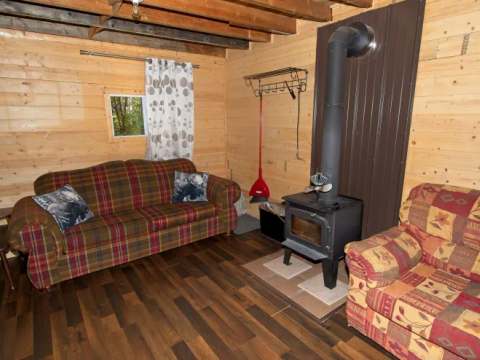 Le salon du chalet comprend deux sofas confortables et un poêle à bois pour vos soirées de détente.
