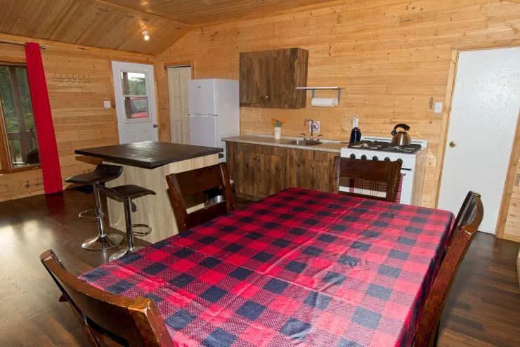 La cuisine équipée et l'espace repas du chalet 3 disposent d'un îlot central et de boiseries.