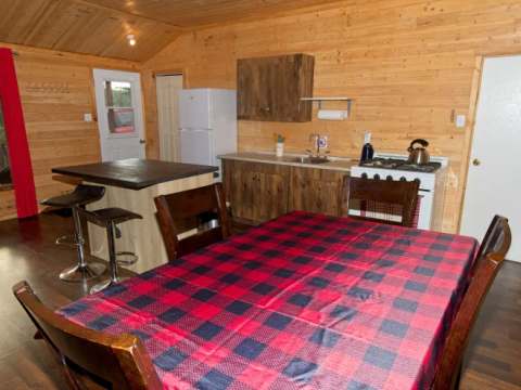 La cuisine équipée et l'espace repas du chalet 3 disposent d'un îlot central et de boiseries.