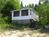Exterior view of cabin 1A located at the edge of the forest.