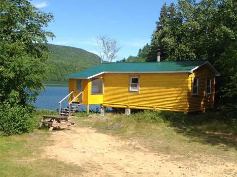 Cottage 2 is located by the lake with an outdoor picnic table.