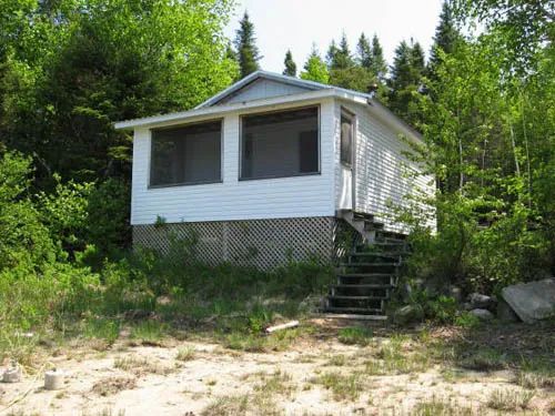 Exterior view of cabin 3 situated in a wooded environment.