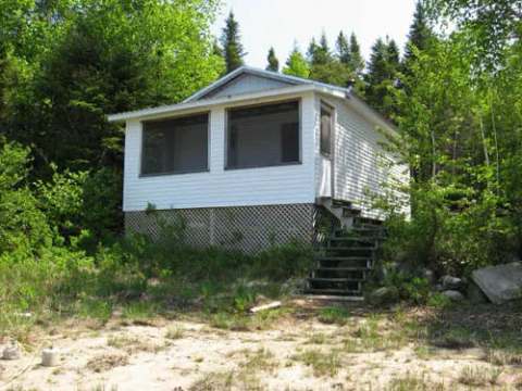 Exterior view of cabin 3 situated in a wooded environment.