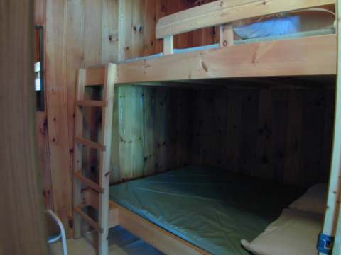A wooden bunk bed is installed in one of the chalet's bedrooms.