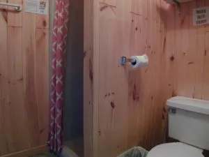 The cottage bathroom includes a shower with a curtain and a toilet.